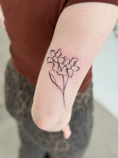 Fine-line blossom bouquet above the elbow