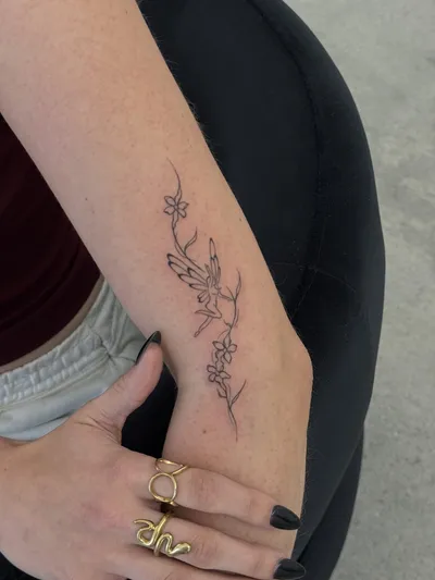 Fine-line florals trailing down the inner forearm to the wrist